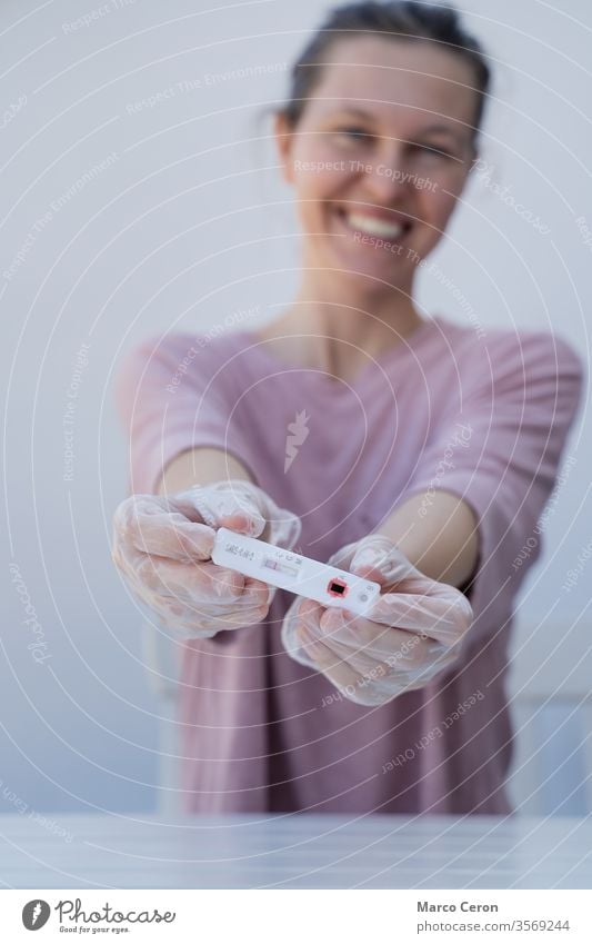 happy woman showing the negative result of coronavirus in a rapid covid test young woman results disposable gloves diagnostic covid-19 diagnosis one person