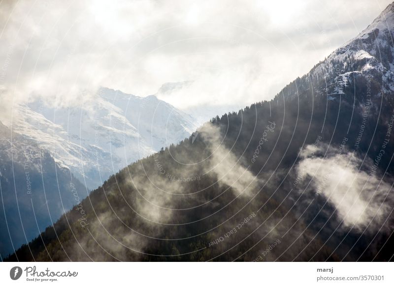 Mountain ridges with clouds mountains Clouds shrouded Snow Alps Austria Mysterious Wisp of cloud Diagonal chill