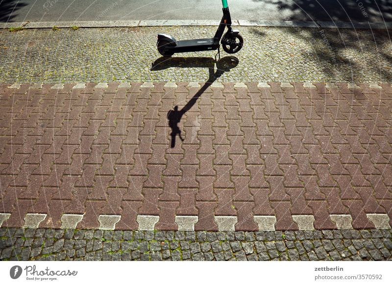 Scooter on the pavement scooter e-roller Local traffic Stand Wait turned off Parking Parking lot Sidewalk Cycle path cycle path Paving stone Light Shadow