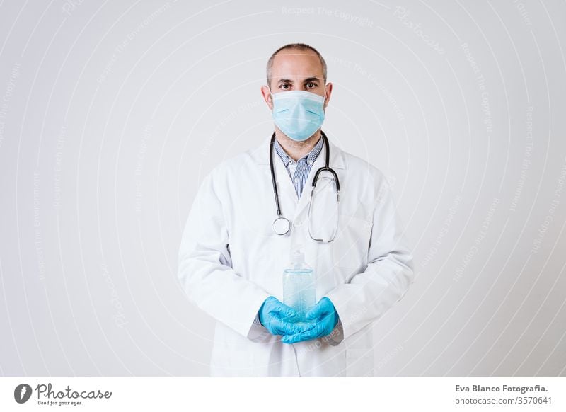 doctor man holding an alcohol disinfectant gel. using protective mask and gloves during corona virus covid 2019 pandemic. Health care and medical concept