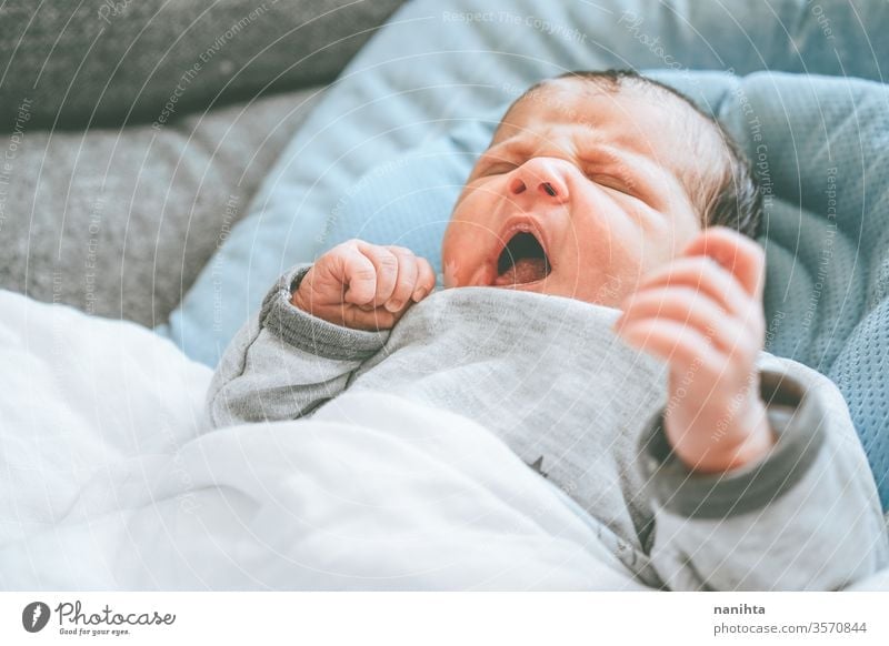 Little new born girl lying down and trying to relax baby birth first day boy mom familly happy happiness care love child yawning crying angry irritability colic