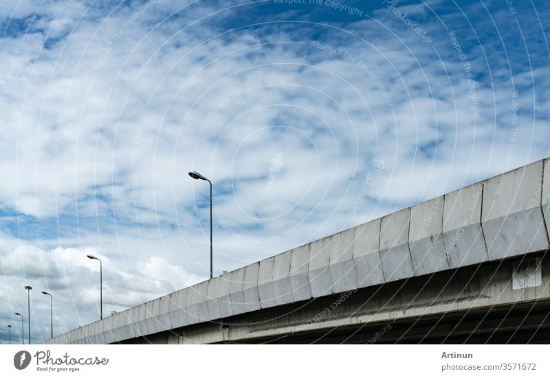 Elevated concrete highway and street lamp pole. Overpass concrete road. Road flyover. Modern motorway. Transportation infrastructure. Concrete bridge engineering construction. Bridge architecture.