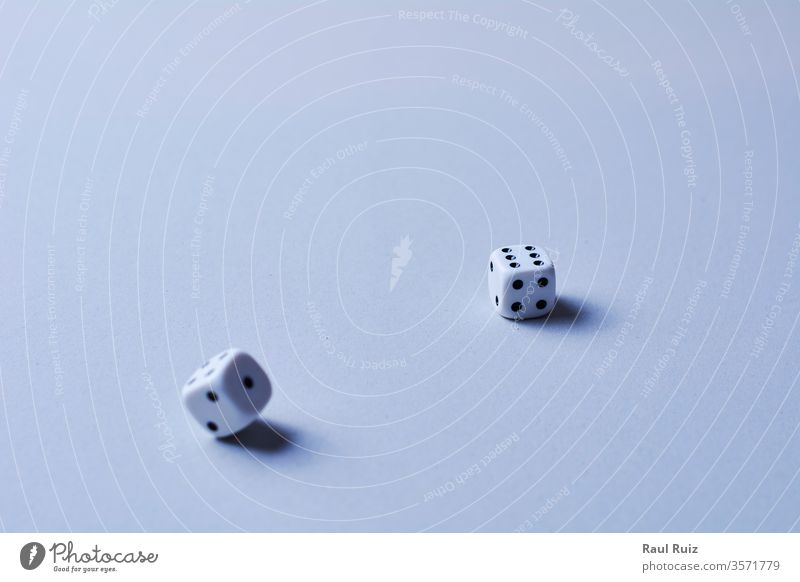 Two dice in motion, on white background, cube desk rolling die winning winner tossing chance betting loss wood luck addiction entertainment casino choice wooden