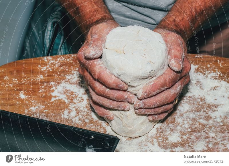 Close-up of man hands kneading bread dough on a cutting board table preparation male kitchen cook cooking chef flour pastry food bakery homemade fresh making