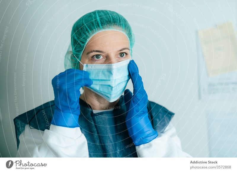 Female doctor in protective mask and goggles medical coronavirus covid woman nurse safety wear put on uniform disease covid19 covid 19 pandemic epidemic