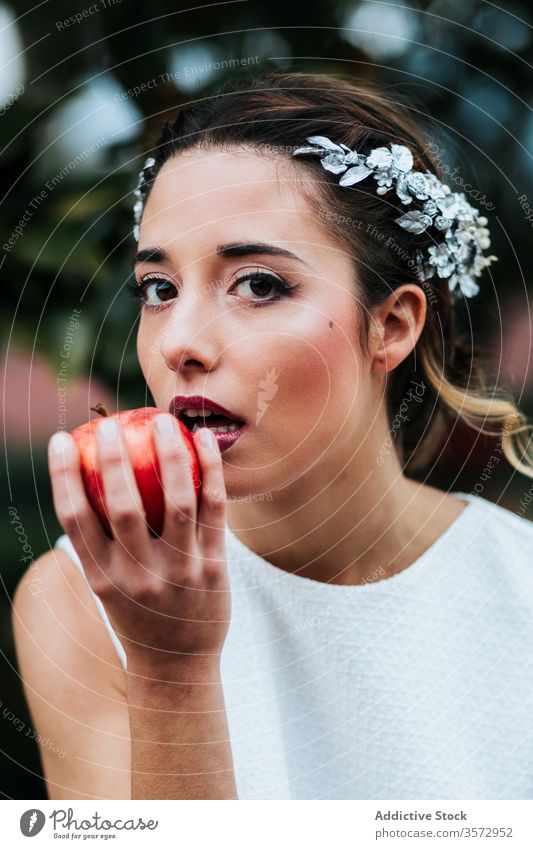 Young bride eating apple from fountain woman garden elegant young fresh wedding female bite model fruit water wet bowl summer park style sit attractive pretty