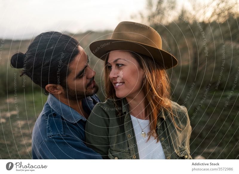 Happy couple hugging in countryside evening date love bush happy tender sunset man woman cheerful romantic lifestyle smile leafless nature relationship together