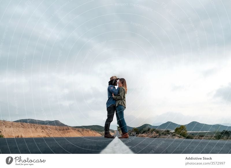 Couple hugging on countryside road couple date love sky cloudy trip together man woman affection casual asphalt romantic relationship girlfriend boyfriend