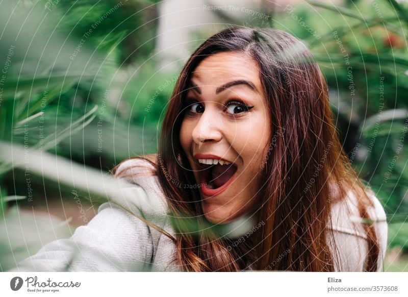 Young woman laughs outside in nature joyfully euphoric positively surprised into the camera portrait Grimace Woman youthful pretty astonished Amazed bunkum girl