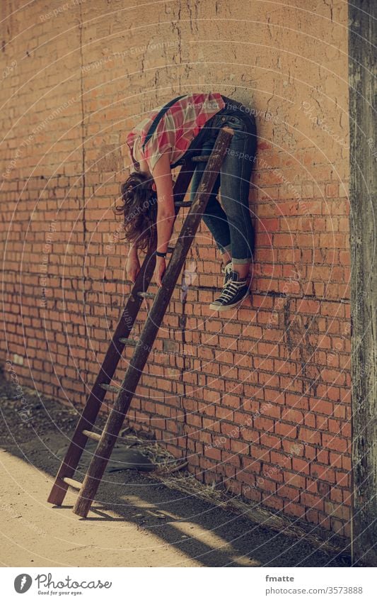 Woman hanging over a ladder Ladder Wall (building) Suspended depression Goof off Distress Crisis relaxation sloth relaxing Career career ladder Exhaustion