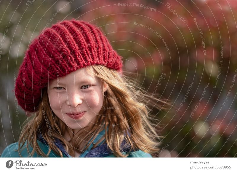 The girl in the cap portrait Winter knitted cap Face Laughter Colour photo Joy long hairs Wind in the hair (if present) Red Knit Headwear smile Humor fun
