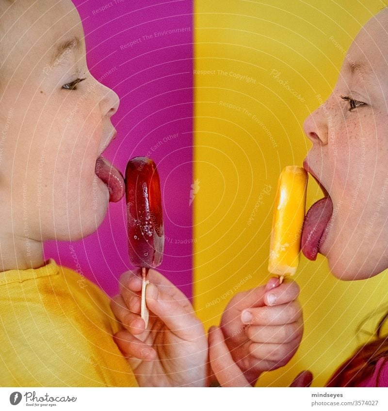 Two children licking ice cream on the style girl Infancy Contrast pink Yellow Ice ice on a stick Summer Ice cream fruit Food Frozen Brothers and sisters Eating