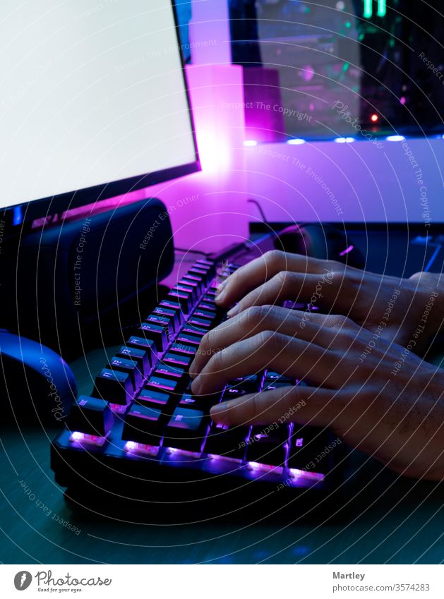 Image of man's hands typing. Hands of a player on a keyboard. Background is Lit with led Lights. computer fingers shooter accessories black office mouse desktop