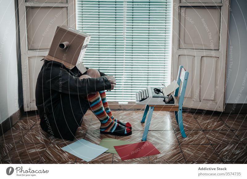 Eccentric anonymous male writer with cardboard box on head man typewriter retro author old fashioned vintage eccentric antique funny story carton creative