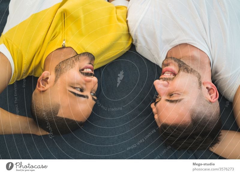 Gay couple laying down on the floor. gay love relationship resting date lovely partnership positive relax freedom life young pride dating looking outdoor