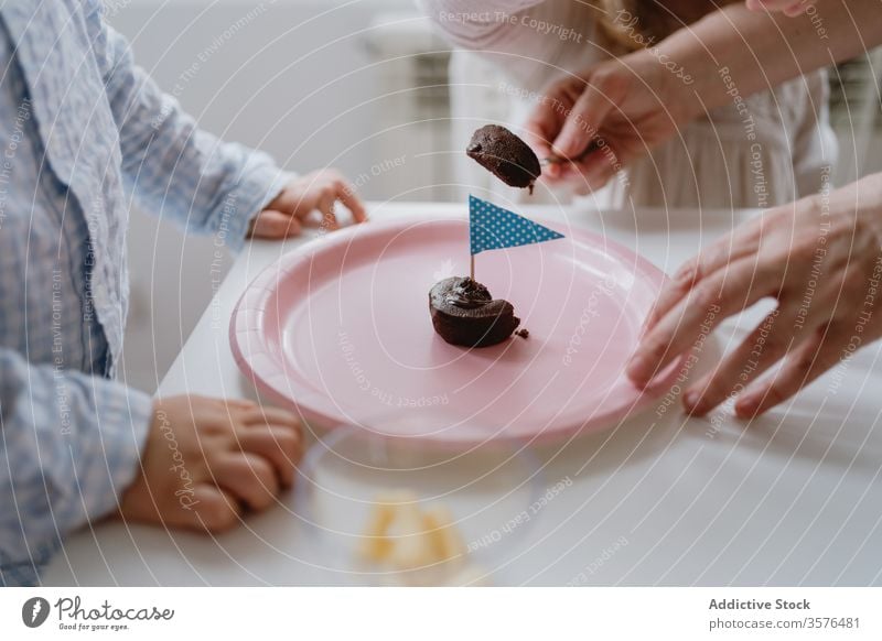 Mother with kids sharing dessert on birthday party mother children share holiday love sweet chocolate together muffin flag pink plate home celebrate delicious