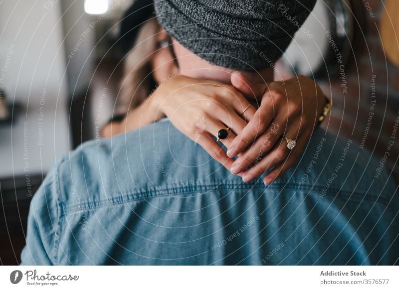 Anonymous couple cuddling in apartment embrace love bonding girlfriend style relationship together boyfriend affection soulmate cuddle ring hand denim jacket