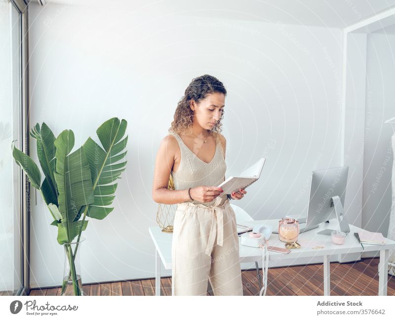 Cheerful woman reading notebook in office notes business smiling work table leaning female palma de mallorca spain style elegant trendy cheerful happy job