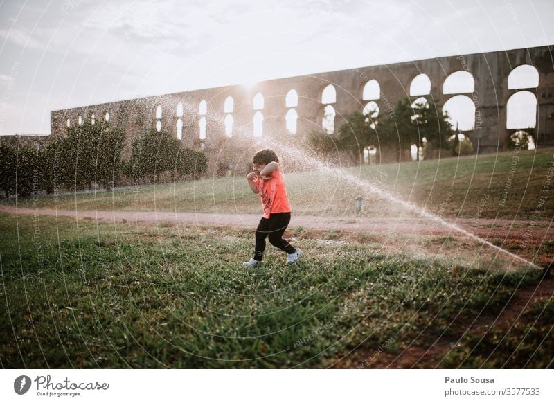 Child playing with water sprinklers Sprinkle Water Summer Summer vacation Children's game childhood Exterior shot Playing Colour photo Vacation & Travel Infancy