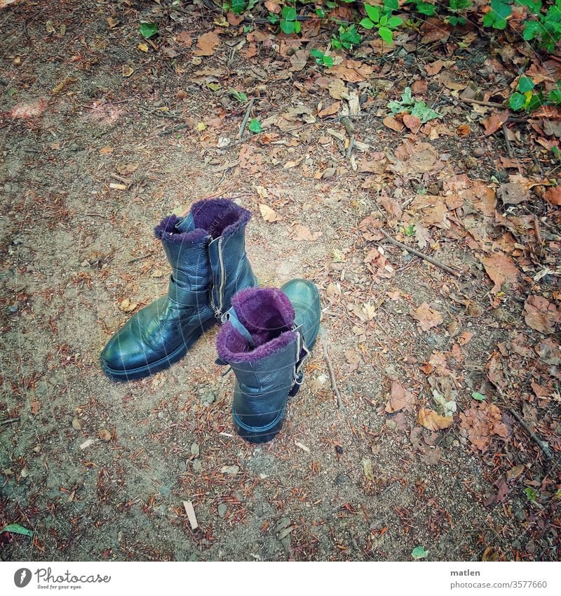 parked boots Park Earth Boots Couple leaves Black purple green deserted free text space Exterior shot Colour photo Close-up Shallow depth of field