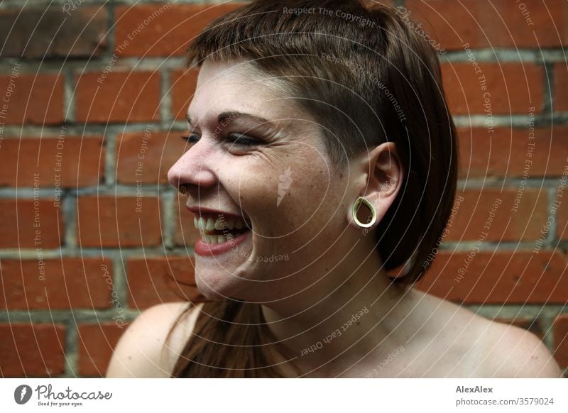 Portrait of a laughing young woman in front of a brick wall fun Free Wild Joy Laughter Cheerful confident Trust Copy Space right Cool (slang) Copy Space left