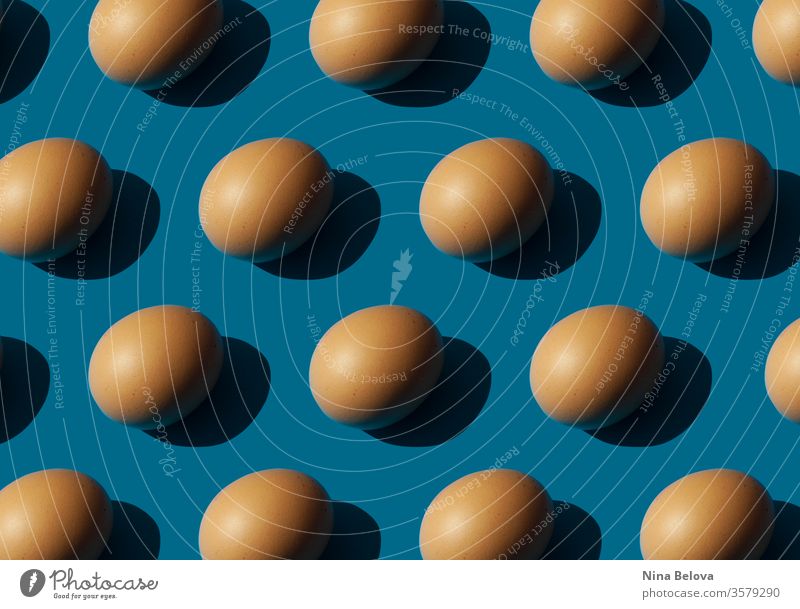 Eggs on blue background, strong light shadows. eggs pattern bright minimalism abstract isometric food above creative classic sunshine sunlight sharp concept