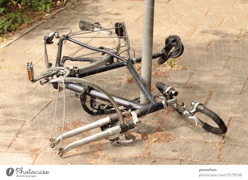 Remains of a bicycle for men chained to a metal post. Bicycle theft. Bicycle lock. Security bicycle lock bike parts bicycle theft Criminal offense Chained up