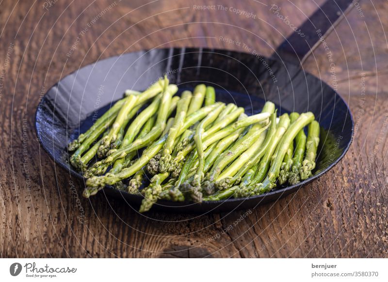 green asparagus in an iron skillet Asparagus boil salubriously Eating Pan cake Fresh vegetarian Preparation Vegetable ingredient Meal Close background Nutrition