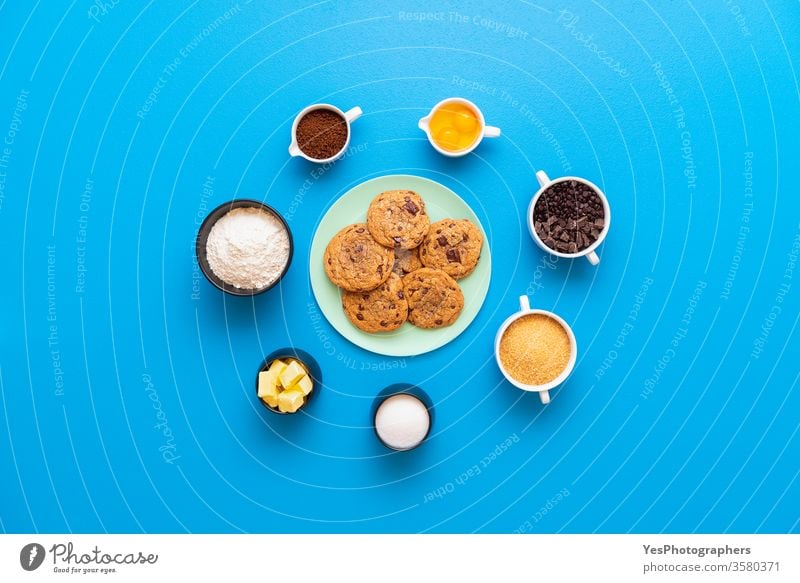 Chocolate chip cookies on a plate and the recipe ingredients above view bakery baking blue background brown sugar butter chocolate chip cookies chocolate chips