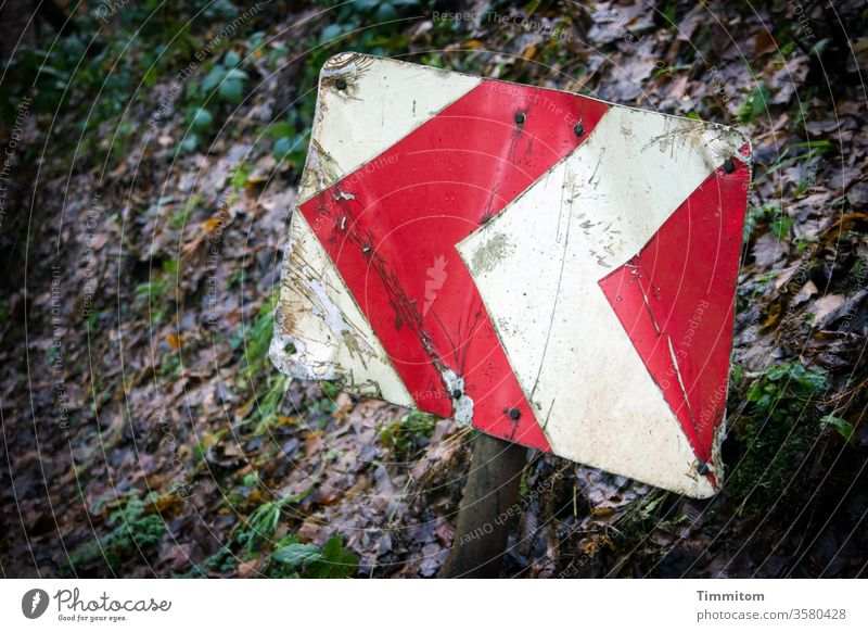 Sign with abundant experience sign Signage Warn Arrow symbol Red White Signs and labeling Warning sign Safety Exterior shot esteem Deserted slope foliage Old