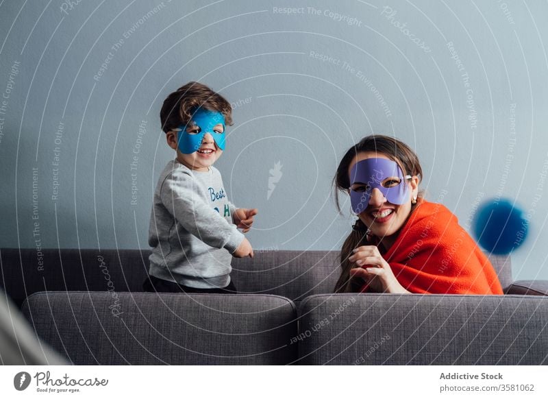 Creative mother and son in superhero masks at home play game creative pretend having fun playful cheerful little weekend boy kid child happy childhood joy