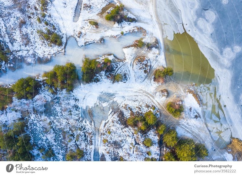 Aerial view of frozen lake. Winter scenery. Landscape photo captured with drone above winter wonderland. aerial nature snow landscape ice forest cold white tree