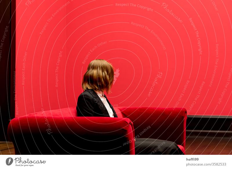 the young woman on the red sofa turns away - the red around her is quite red... Red red room Room Young woman Looking into the camera Rotation Swing Spirited
