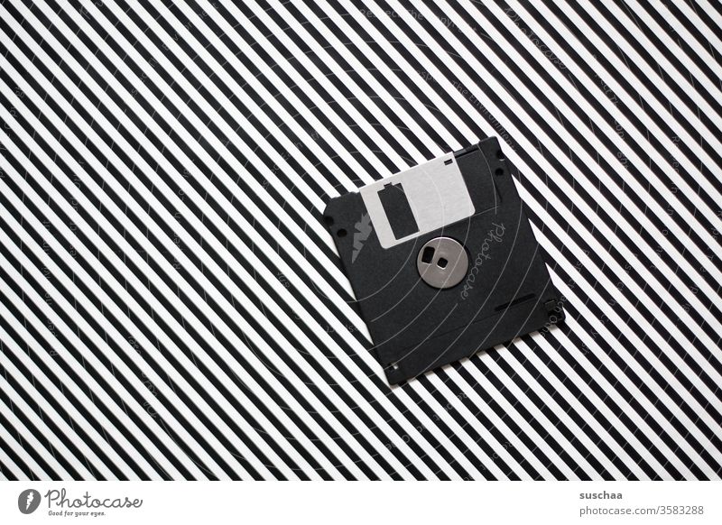 old dicette on striped background Diskette Data storage Archaic outdated Floppy disk drive Old Technology Nostalgia Retro Metal Magnetic Plastic floppy disk