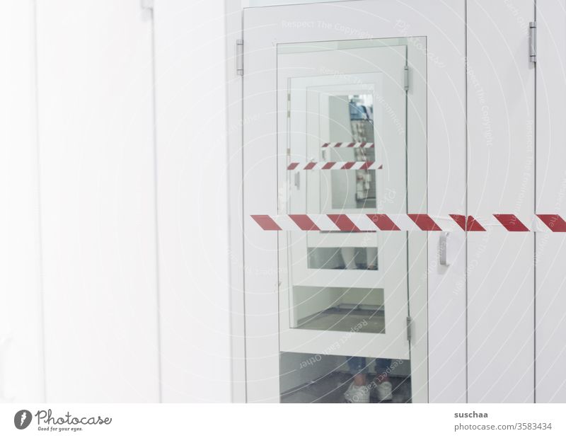 locked changing room with feet of a person reflected in the opposite cabin Shopping shop buy clothes Clothing store changing cubicle Mirror Mirror in the mirror