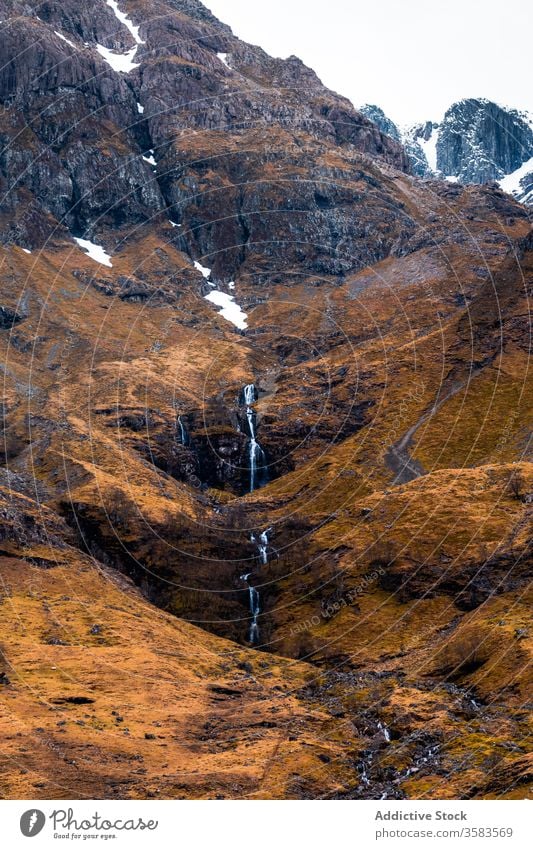 Rocky mountain slope with waterfall rock rough stream landscape nature highland leafless environment stone wild travel tourism formation scotland glen coe