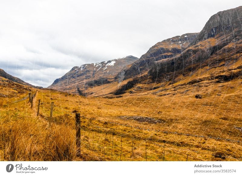 Remote road in endless mountainous valley highland rock nature landscape countryside route ridge range terrain scotland glen coe sky cloudy grass spring travel
