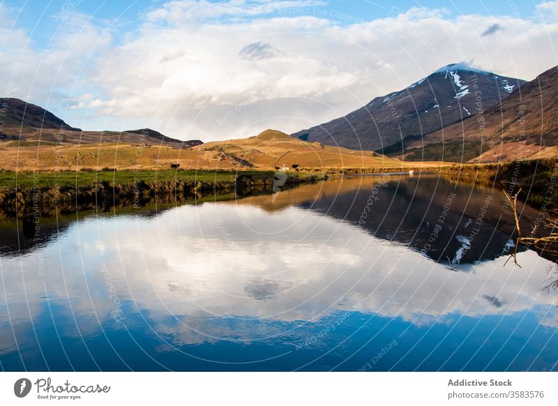 Cloudy sky and mountain reflected in lake reflection landscape calm peak nature scotland highland glen coe water scenery scenic environment peaceful wild serene