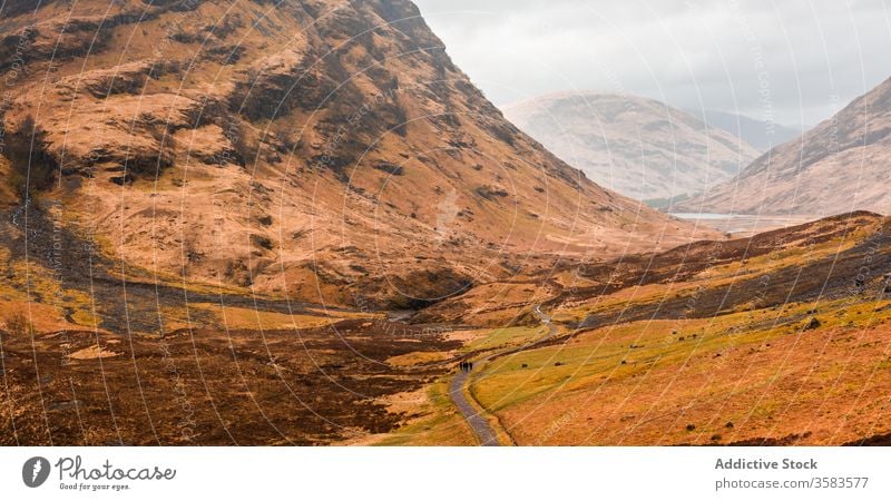 Remote road in endless mountainous valley highland rock nature landscape countryside route ridge range terrain scotland glen coe sky cloudy grass spring travel