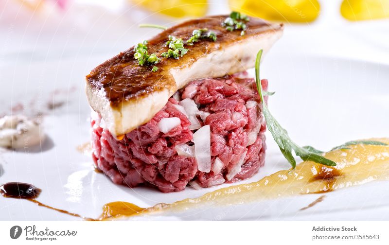 Served steak tartare with foie gras and sauce haute cuisine gourmet dish gastronomy expensive luxury delicatessen raw liver glaze culinary serve plate food