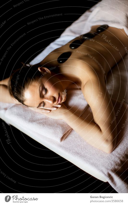 Young woman having a hot stone massage therapy alternative back beautiful beauty black body calm care caucasian clean clinic close concept dayspa enjoying