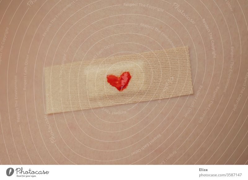 A plaster with a little red heart on it on skin. Concept lovesickness, injury and care. pavement Heart Red Lovesickness violation concept Considerate To console