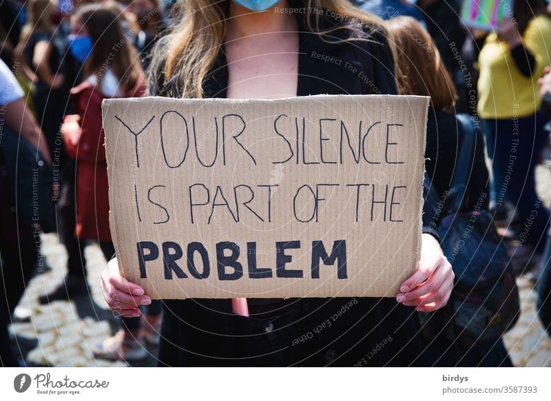 blacklivesmatter. A young woman carries a sign that reads, your silence is part of the problem. Civil courage against police violence and violence in general