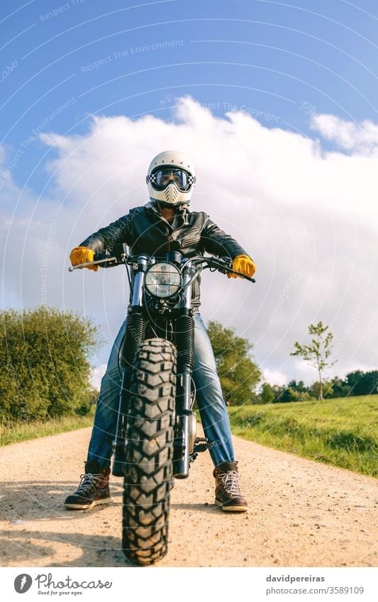 Man with helmet riding custom motorbike man view from below biker vintage wheel retro rider vehicle transport motorcycle posing young adult one people person