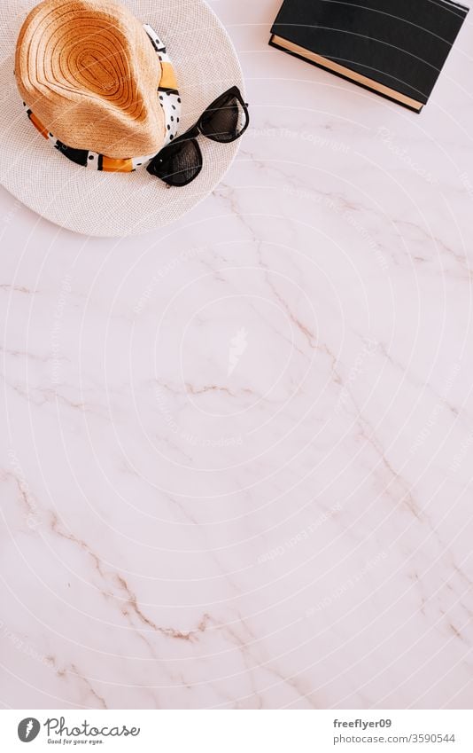Flat lay of objects related to summer, spring and leisure against a marble background sunglasses hat book reading flat lay flatlay copy space copyspace still