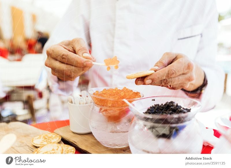 Man serving snack with caviar food serve flatbread starter appetizer buffet put person tradition yummy tasty delicious meal dish gourmet service treat cuisine
