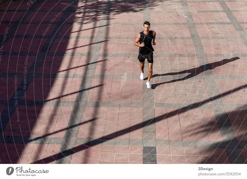Top view athlete runner training at road in black sportswear. man adult jogging lifestyle athletic sporty exercise young active healthy summer activewear fit