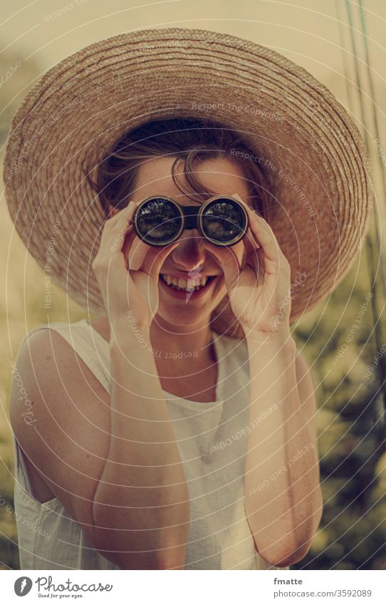 Woman with binoculars Vacation & Travel Binoculars Laughter Straw hat Land in sight Vantage point search search & find Find Discover Far-off places Summer