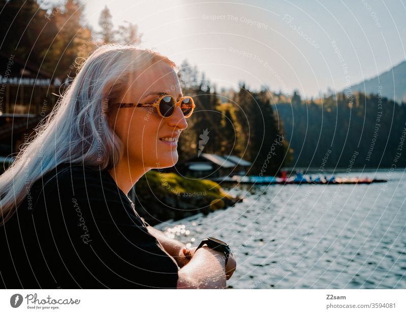 Young woman at Spitzingsee Nature Landscape green Summer sunglasses Retro Blonde long hairs already pretty youthful teen Lifestyle Laughter smile Blow Wind