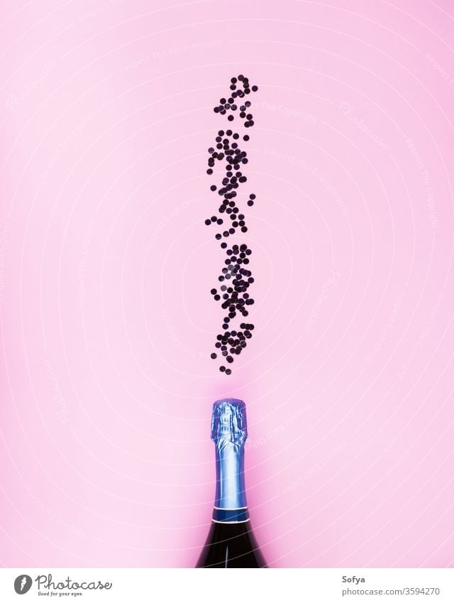 Champagne bottle and confetti flow on pink new year champagne bubbles alcohol holiday valentine anniversary party date festive birthday web background minimal